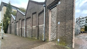 A brick building with a herringbone-patterned pavement. - Cozy and stylish room near Oss highlights, with free parking and fast WiFi for a comfortable and convenient stay. (Oss)