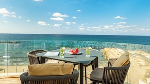 A table with drinks and a plate of fruit, overlooking a beach and the sea. - Rooftop Jacuzzi Penthouse by Sea N' Rent (Haifa)