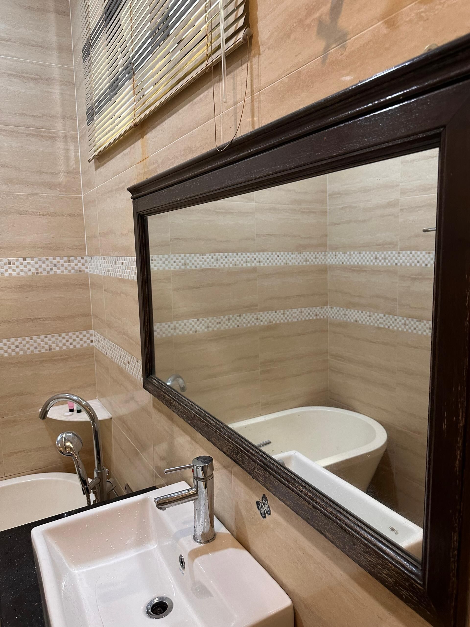 A bathroom with a white sink, a mirror, and a bathtub.