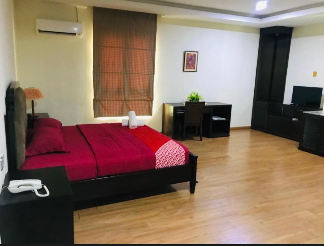 Une chambre d’hôtel équipée d’un lit, d’un bureau, d’une chaise, d’une télévision et d’un appareil de climatisation.