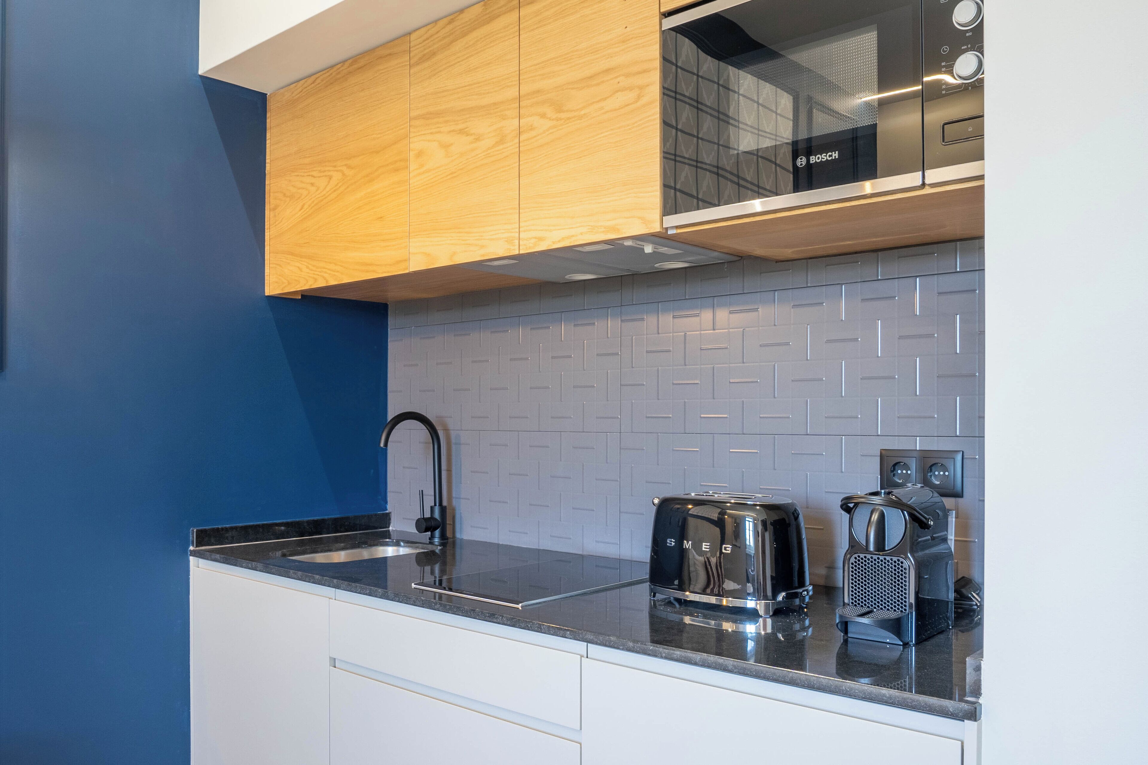 A modern kitchen with a Bosch microwave, a toaster, and a coffee maker on the counter.