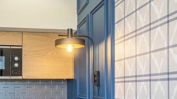 A modern kitchen with a built-in oven, a wooden cabinet, and a patterned backsplash.