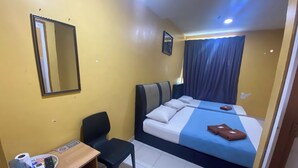 A hotel room with a bed, a desk with a chair, a mirror, and a window with curtains. - Hotel O De Anjung (Muadzam Shah)
