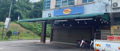 A building with a sign for "Restoran Ayia de cafe" and a closed garage door.