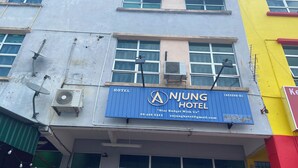 A building with a sign for Anjung Hotel, featuring a contact number and email address. - Hotel O De Anjung (Muadzam Shah)
