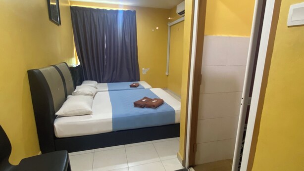 A hotel room with a bed, a desk, a chair, and a bathroom door. - Hotel O De Anjung (Muadzam Shah)