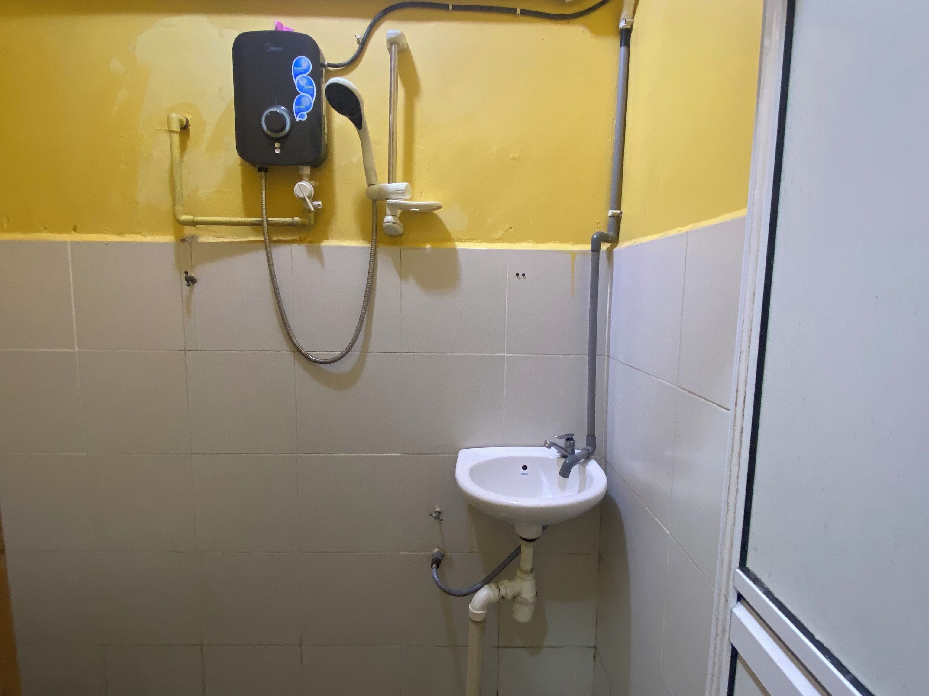A small bathroom with a shower, a sink, and a toilet.