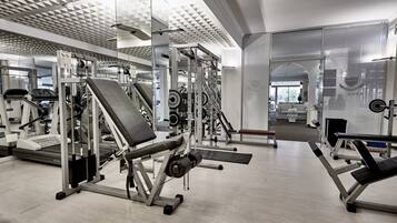 A gym with various exercise equipment, including treadmills, weight machines, and free weights.