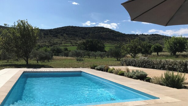 Una piscina rectangular amb un videtell daurat, envoltada d'una zona pavimentada de formigó.