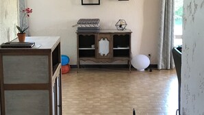 Habitació amb terra de fusta, un armari de fusta amb prestatges i un moble penjat a la paret amb diversos objectes.