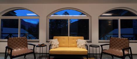 Un interior moderno con un sofá, dos sillones y una alfombra estampada.