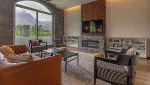 Una sala de estar con chimenea, televisión y vistas a montañas.