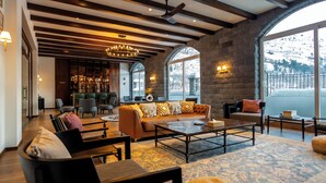 Un vestíbulo amplio con un sofá grande, una mesa de centro y una zona de bar.