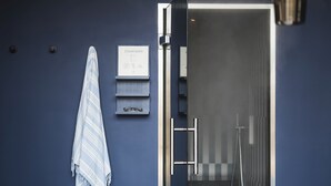 Une salle de bain moderne avec un panneau indiquant la présence d’un hammam, une serviette et un panier en osier posé sur le sol.