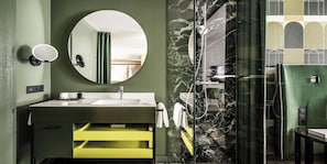 Enjoy a refreshing shower in the bathroom, featuring a round mirror above the sink and a separate shower area.