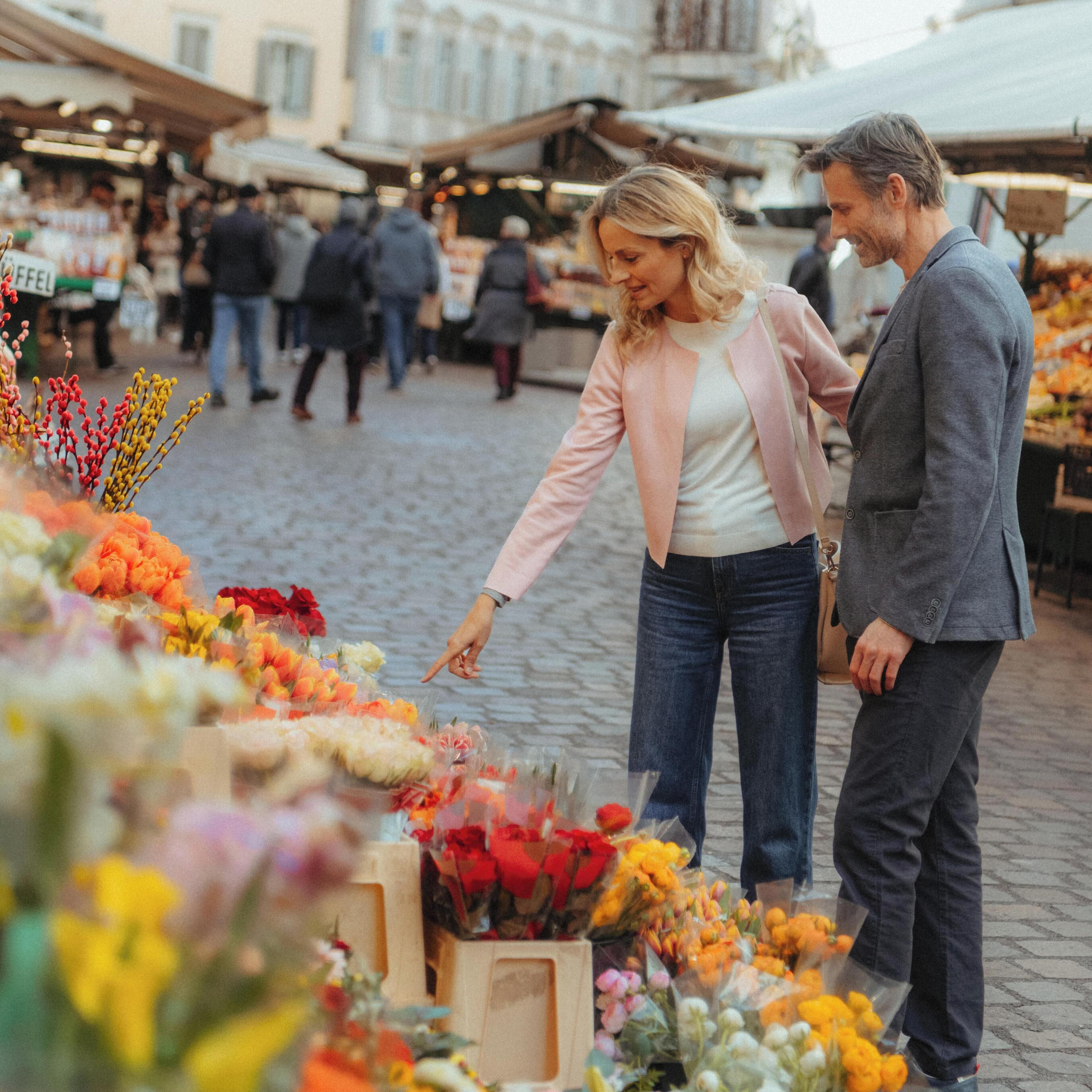 Un vivace mercato all'aperto con persone che curiosano tra le bancarelle.
