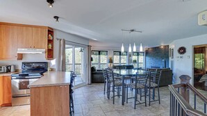 Una cucina moderna con isola centrale, elettrodomestici in acciaio inossidabile e zona pranzo con tavolo e sedie.