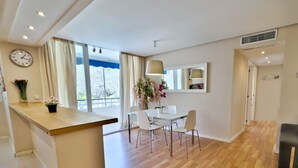 A modern kitchen with a wooden countertop, a dining area with a white table and chairs, and a large window with curtains. - Cozy holiday apt Marbella center. (Marbella)