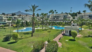 A resort with multiple swimming pools, palm trees, and a mountainous backdrop. - Spacious Apartment with Terrace near Beach Puerto Banus (Marbella)