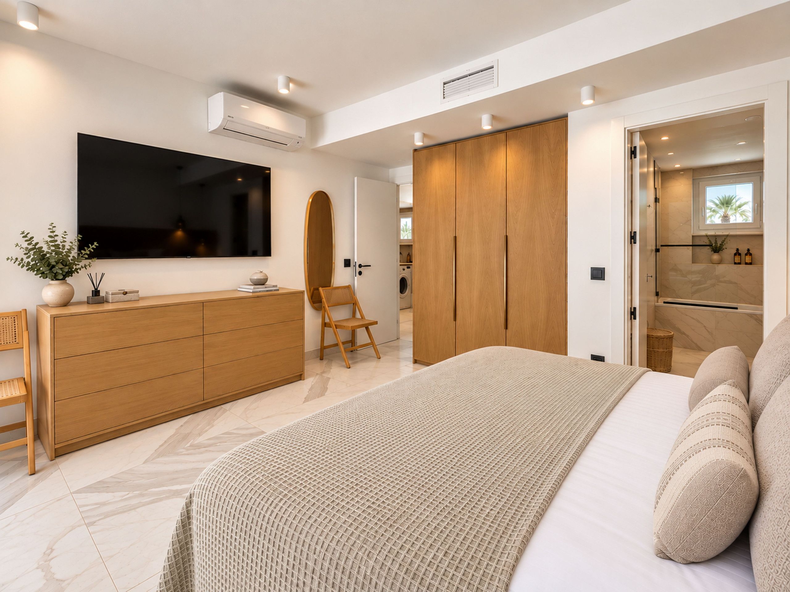 A modern bedroom with a bed, a dresser, a TV, and a wardrobe.