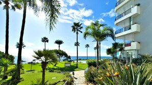 A pathway leading to a building with a view of the sea. - Beachfront Apartment with Swimming Pools (Mijas Costa)