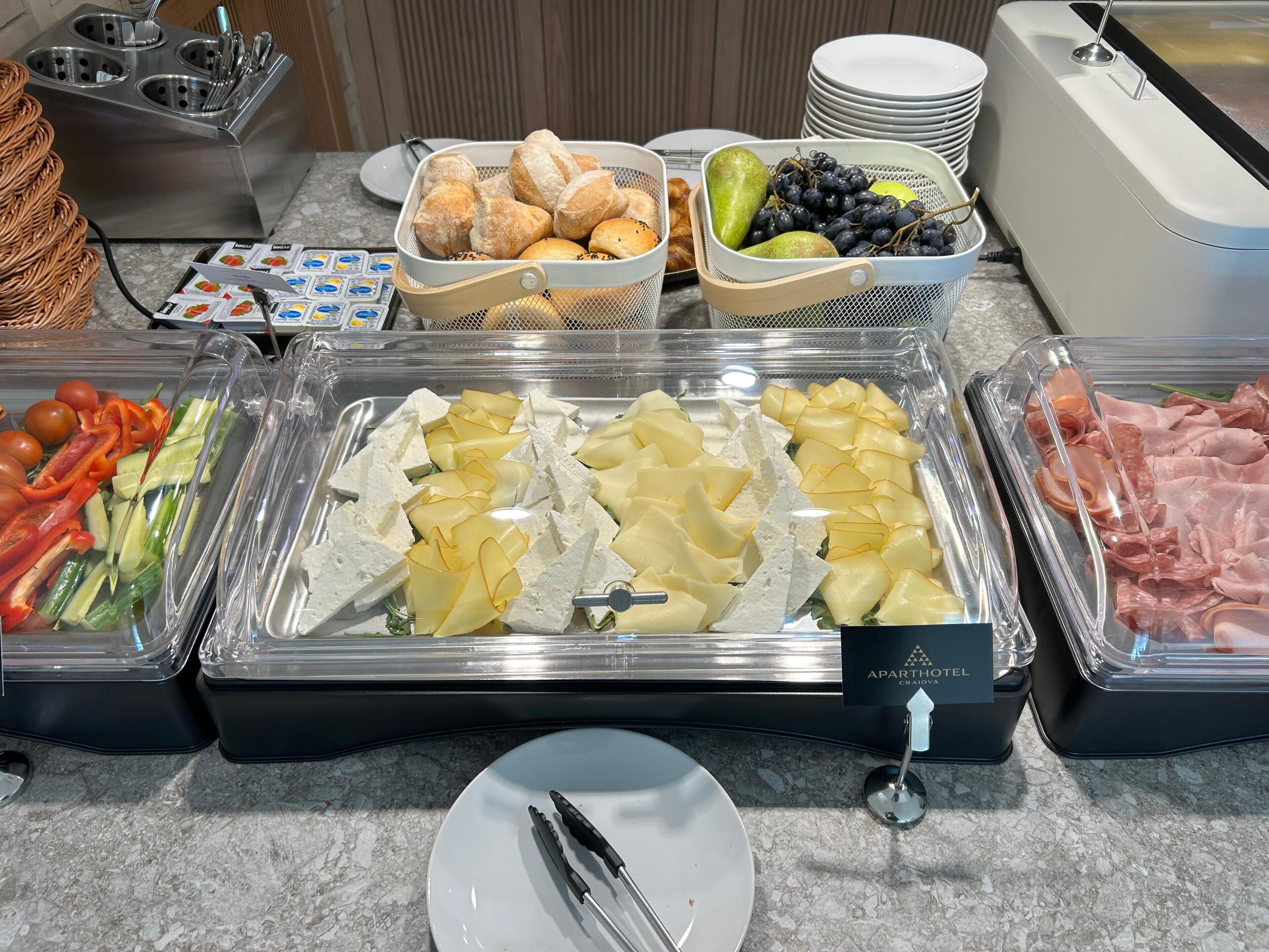 A buffet with various food items including fruits, vegetables, and meats.