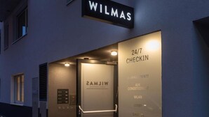 A hotel entrance with a sign reading "WILMAS" and a directory listing amenities like 24/7 check-in, air conditioning, Wi-Fi, and a lobby. - Double Room - Disability access by Arbio (Vienna)