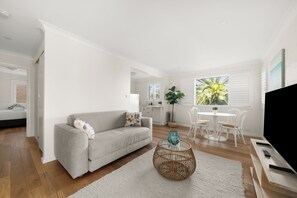 Relax in this stylish living room with a grey sofa, round coffee table, and flat-screen TV.