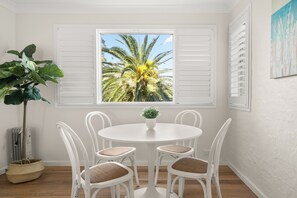 Relax in this serene space with a round table and four chairs, a potted plant, and a beautiful view.