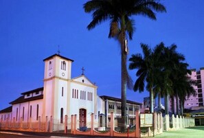A church with a bell tower, palm trees, and a fence. - Ap Completo Parq. Aquát. Incrível Grátis (Caldas Novas)