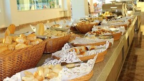 A buffet with various breads and pastries in wicker baskets. - Ap Completo Parq. Aquát. Incrível Grátis (Caldas Novas)