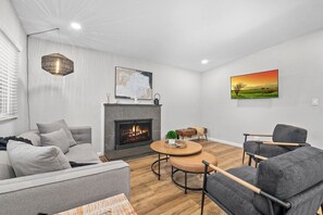 Ein modernes Wohnzimmer mit Kamin, rundem Couchtisch und einer Couch.