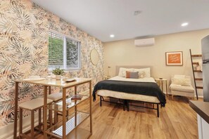 Ein modernes Schlafzimmer mit Bett, Nachttischen, Schreibtisch und Stuhl.