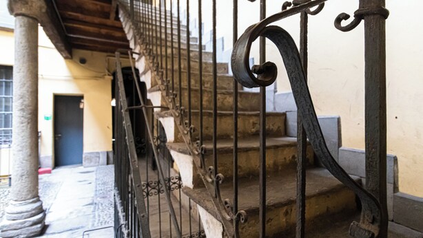 Un escalier orné de rampes en métal ouvragé et de marches en pierre.