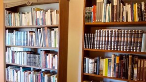Una biblioteca con varias estanterías de madera llenas de libros.