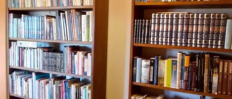 A library with multiple wooden bookshelves filled with books.