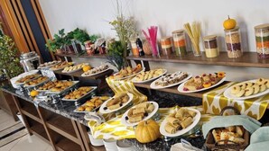 Una mesa de buffet con diversos alimentos y salsas.