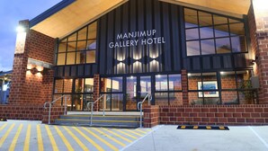 The exterior of Manjimup Gallery Hotel with a brick facade, large windows, and a covered entrance. - Gallery Hotel Manjimup (Manjimup)