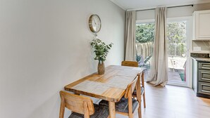 A dining area with a wooden table, chairs, a clock, and a plant. - Modern Retreat w/ Fire Pit Near Harrison Bay! (Chattanooga)
