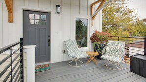 A wooden deck with two rocking chairs and a small table, a gray door, and a welcome mat. - Mtn-view Gem w/ Grill: 2 Mi to Dtwn Livingston (Livingston)