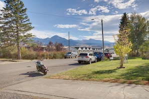A residential street with parked cars and a motorcycle, houses in the background, and mountains in the distance. - Mtn-view Gem w/ Grill: 2 Mi to Dtwn Livingston (Livingston)