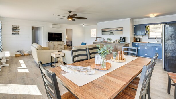 A spacious living area with a wooden dining table, a sofa, and a kitchen in the background. - Decks & Boat Dock: 'the View on Lay Lake!' (Shelby)