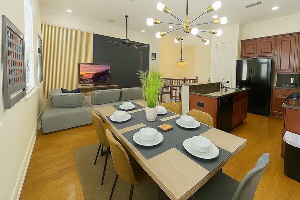 A modern apartment with a dining area, kitchen, and living space.