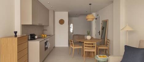 A modern apartment with a kitchen, dining area, and living room.