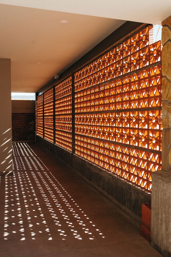 A corridor with patterned walls and a concrete floor.