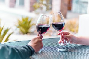Two people holding wine glasses at a table with a metal surface. - Hotel El Dorado (Tecate)