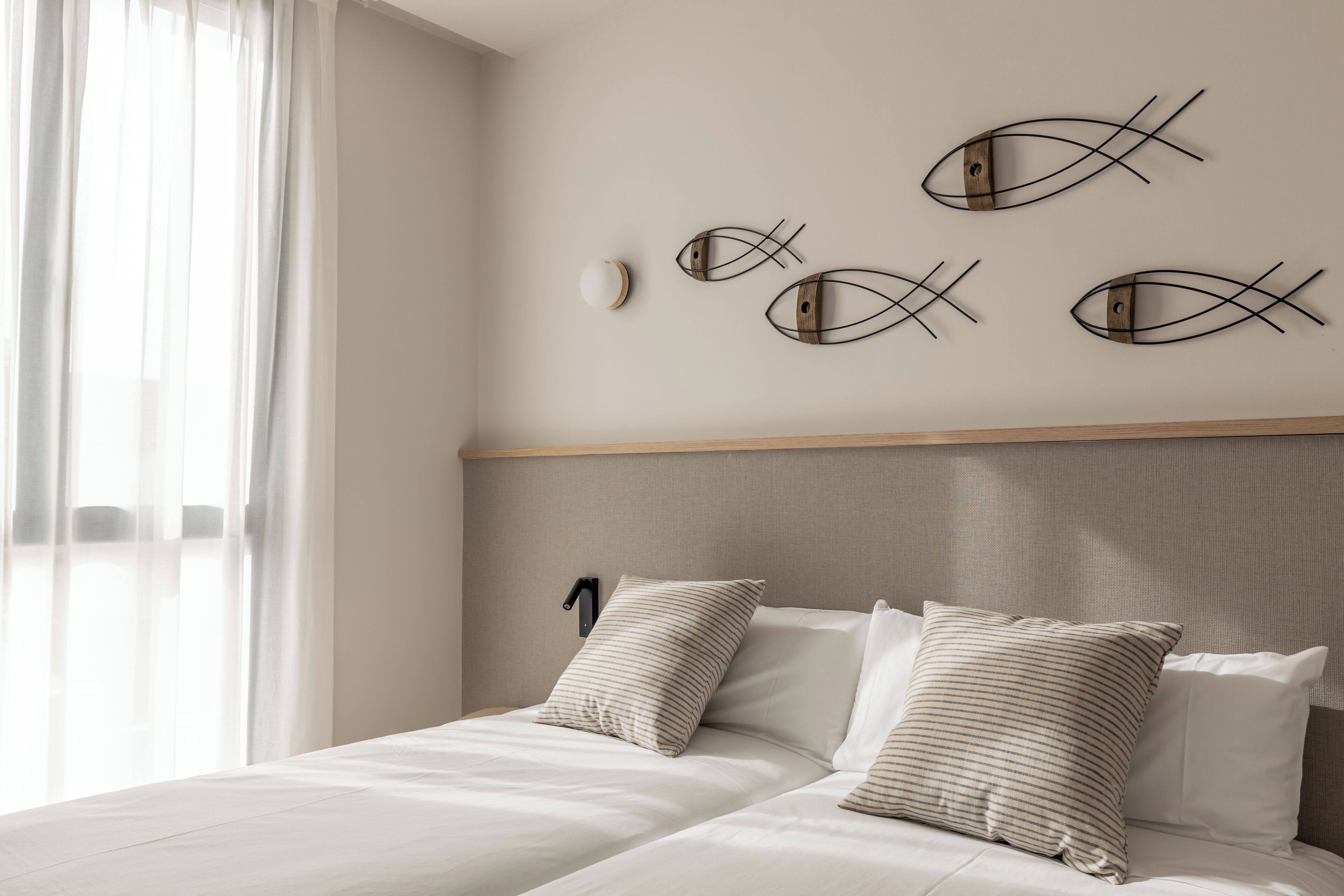 A hotel room with a bed, a headboard, and wall art.