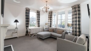 A living room with a sofa, a table, and a chandelier. - A Historic Wellington Escape (Wellington)