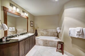 A bathroom with two sinks, a large mirror, a bathtub, and a stool. - Luxury 4 Bedroom Condo on Peak 8 4 Condo (Breckenridge)