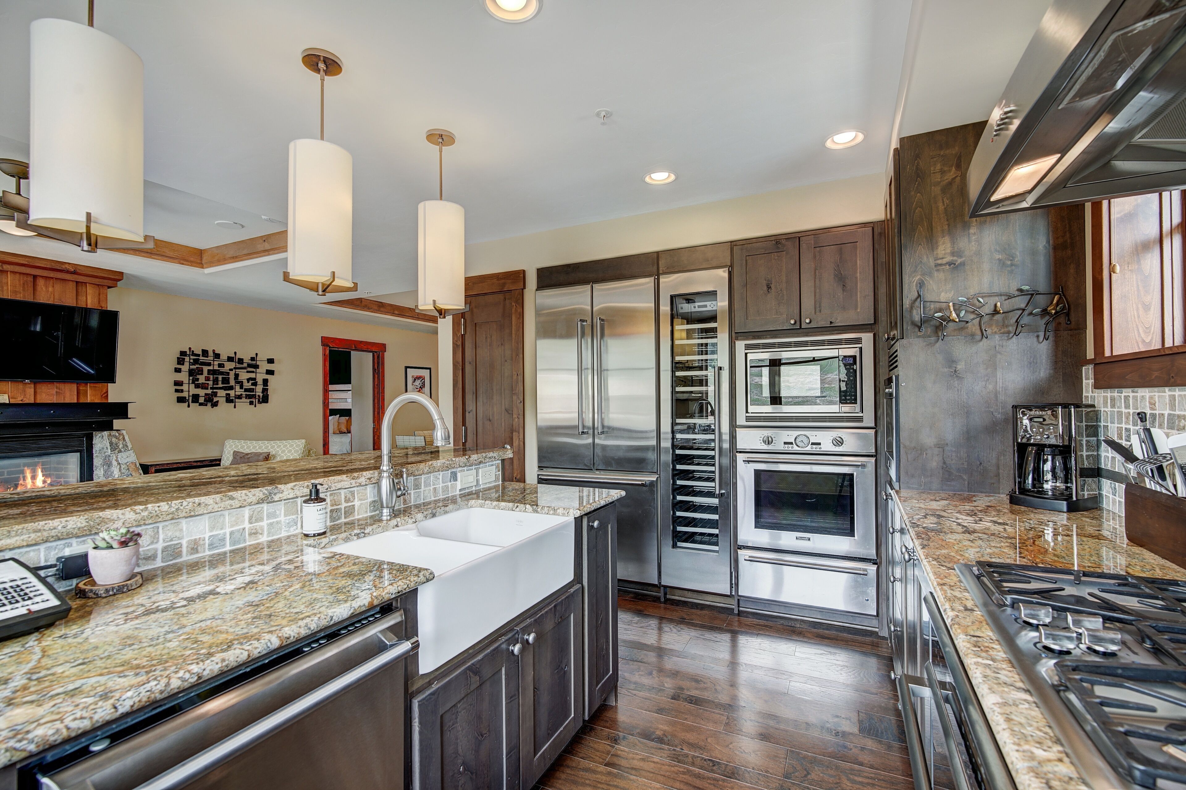 A modern kitchen with stainless steel appliances, a granite countertop, and wooden cabinets.